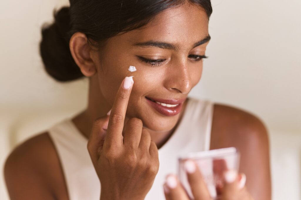 Skincare, Beauty Routine. Smiling Woman Applying Face Cream for Skincare and Beauty Routine