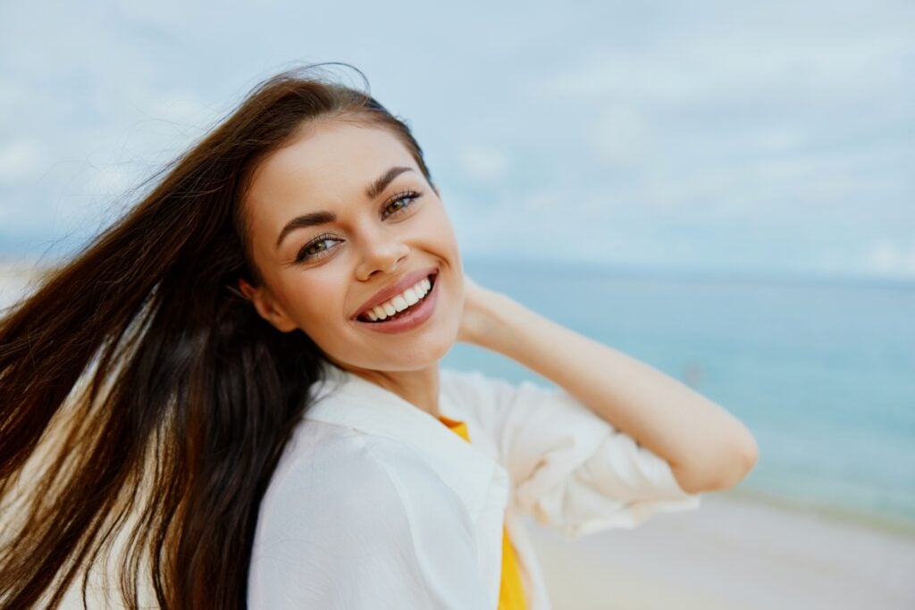 Portrait of a happy woman smile with teeth with long hair brunette summer travel and feeling of