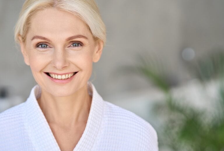 Portrait of smiling mid age woman looking at camera. Skin care concept.